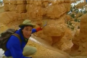 Bill Nye kneeling down near eroded rock formations